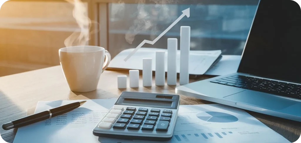 Financial growth concept with a calculator, laptop, coffee cup, and documents on a desk, featuring a rising bar chart and upward arrow symbolizing business performance, revenue growth, and data-driven success.